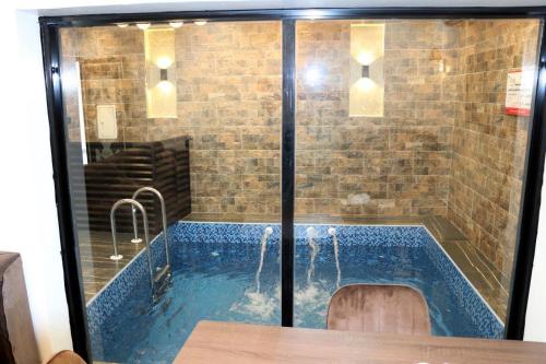 a swimming pool with a shower in a room at نيلوفر بيتي in Sūq al Aḩad