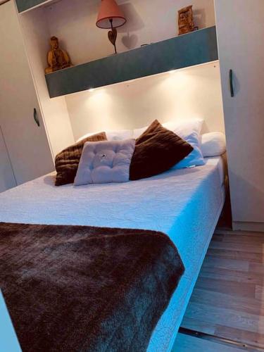 une chambre avec un lit avec des draps et des oreillers bleus dans l'établissement Chalet au calme à Sagone en Corse, à Sagone