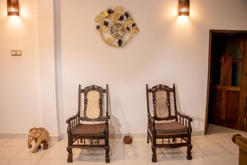 two chairs and a dog sitting in a room at DiNi Galle in Galle