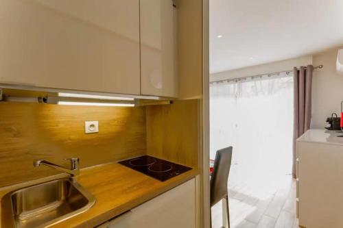 uma pequena cozinha com um lavatório e um fogão em Studio Central 300 m des plages, au calme em Cannes