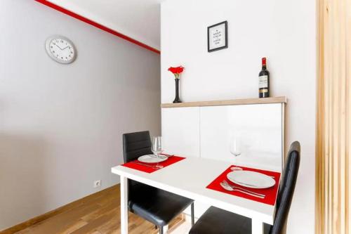 une salle à manger avec une table et des chaises blanches dans l'établissement Palais Lilou - Studio Central 300 m des plages, au calme, à Cannes