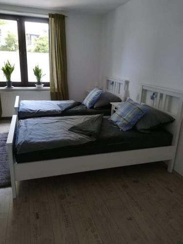 a bed in a bedroom with two pillows on it at Appartment, gemütlich u. zentral in Hattingen
