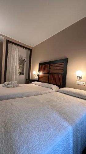 2 camas en una habitación de hotel con 2 camas sidx sidx sidx en Hospedería Nieves Centro en Chipiona
