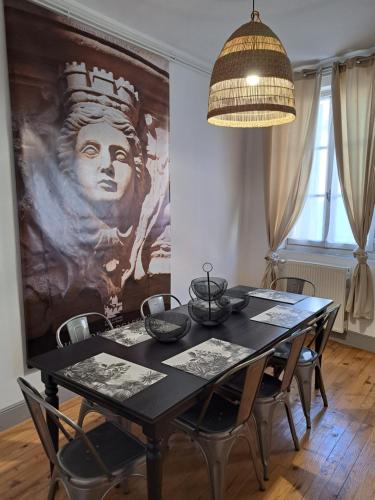 une table de salle à manger avec des chaises et un tableau au mur dans l'établissement Maison rue Trivalle, à Carcassonne