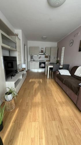 a living room with a couch and a wooden floor at Civico 32 in Montalto Dora