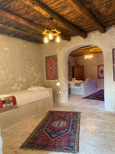 a bedroom with a bed and a rug on the floor at Seven Rock Cave Hotel in Goreme