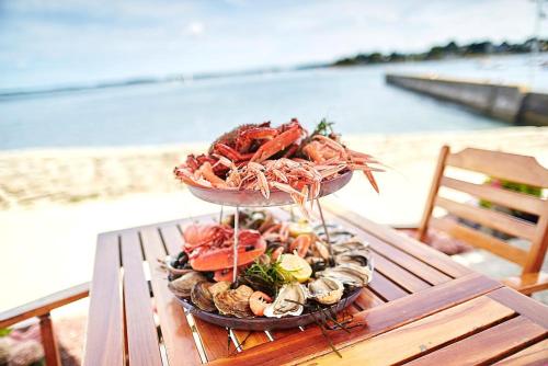 un piatto di pesce su un tavolo sulla spiaggia di Vacances face à la mer! a Guidel