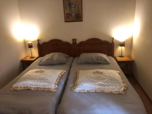 2 Einzelbetten in einem Schlafzimmer mit 2 Lampen in der Unterkunft Le Prieuré a Guilly Vatan 