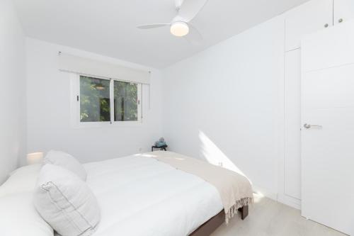 - une chambre blanche avec un lit et une fenêtre dans l'établissement Barquilla Apartment - Kura Homes, à Marbella