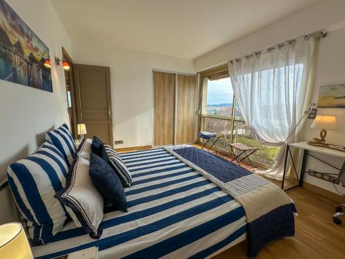 une chambre avec un grand lit avec une grande fenêtre dans l'établissement Vue Mer, face Port, proximité Centre et Plage, à Antibes