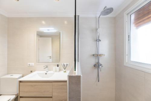 La salle de bains blanche est pourvue d'un lavabo et d'une douche. dans l'établissement Barquilla Apartment - Kura Homes, à Marbella
