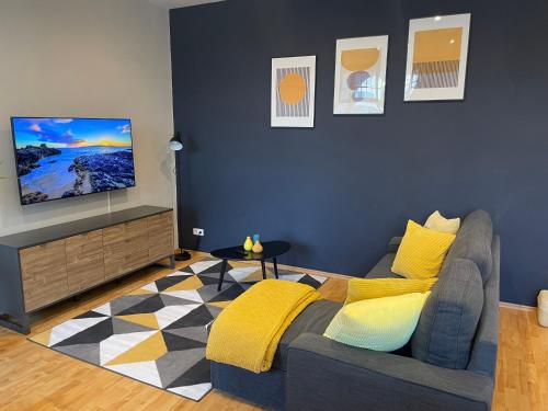 uma sala de estar com um sofá e uma televisão de ecrã plano em Stadtoase Berlin nähe Olympiastadion em Berlim