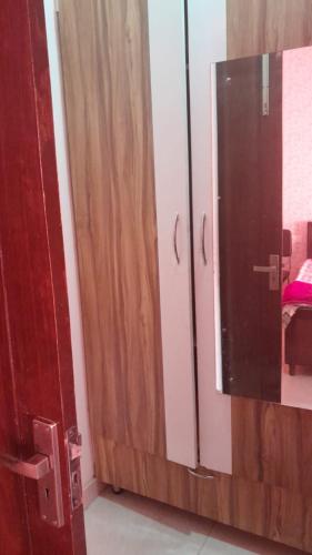 a bathroom with a mirror and a wooden door at Rellio Bed and Breakfast in Kharar