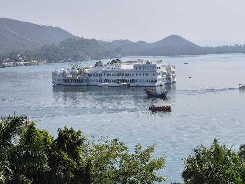 a large white building in the middle of a lake at Hotel Lake Star in Udaipur