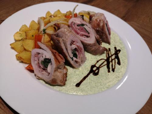 a plate of food with meat and vegetables on a table at Penzion DON in Třebíč