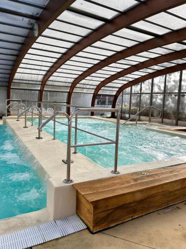 une grande piscine intérieure avec une grande fenêtre dans l'établissement Notre bulle du ferret, à Lège-Cap-Ferret