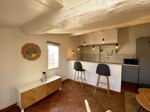 - une cuisine avec deux tabourets et un comptoir dans une pièce dans l'établissement Appartement cocooning Terrasse - Centre Hist- Clim, à Aix-en-Provence