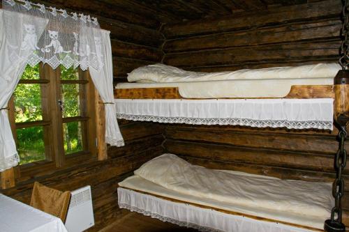2 lits dans une cabane en rondins avec 2 fenêtres dans l'établissement Vango Holiday Village, à Laiksaare