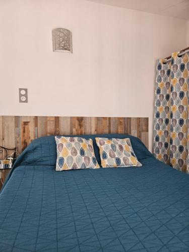 - une chambre avec un lit bleu et 2 oreillers dans l'établissement la farigoulette, à Saintes-Maries-de-la-Mer