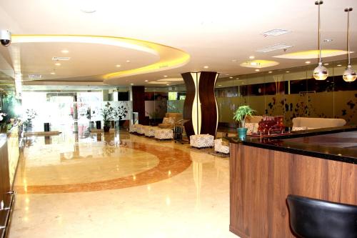 a lobby with a bar and chairs in a building at Best Western Papilio Hotel in Surabaya