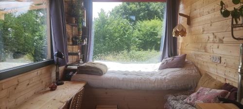 a room with a window with a bed in it at Tiny house bucolique in Saint-Brieuc-de-Mauron