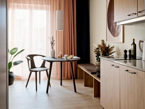 uma cozinha com uma mesa e uma sala de jantar em Aura Apartment Hotel em Arhus