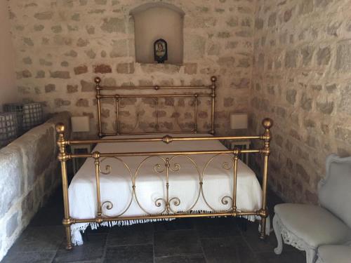 Bett in der Ecke eines Zimmers mit Steinwänden in der Unterkunft Villa Maros in Scicli
