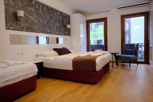 a hotel room with two beds and a chair at Taksim Green Suites in Istanbul