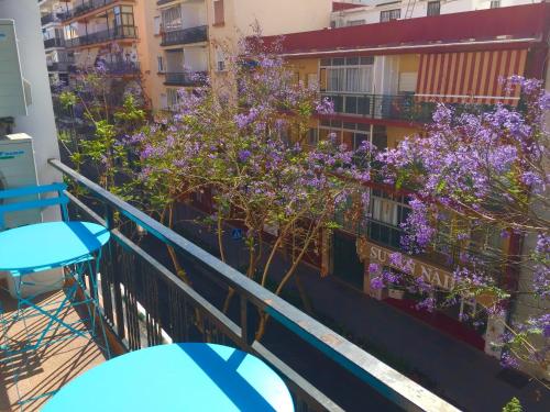 un balcón con flores púrpuras en un edificio en Ramon - Y - Cajal, en Fuengirola