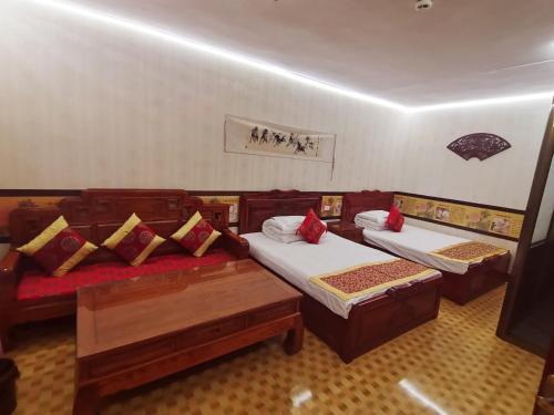Habitación con 2 camas y sofá. en Pingyao Yan Family Homestay en Pingyao