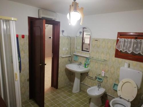a bathroom with a sink and a toilet and a mirror at CASA NONNA LUCIA nel cuore del Salento in Latiano