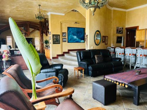 a living room with leather furniture and a table at Beachfront House in Great Brak River