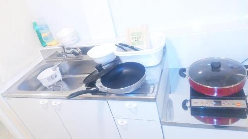 a kitchen counter with a sink with pots and pans at Hananogo Ikebukuro - Vacation STAY 16064v in Tokyo