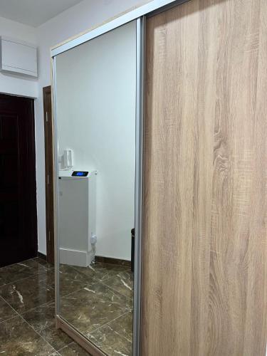 a sliding glass door in a room with a mirror at Apartmani Profesional Pajkovic in Valjevo