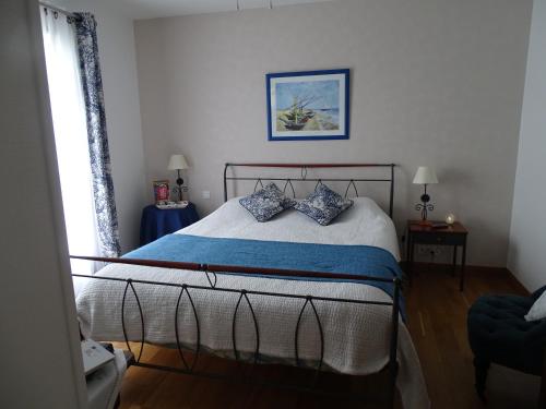 a bedroom with a bed with blue pillows on it at Villa Les Hortensias B&B in Arcangues