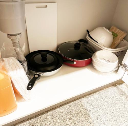 ein Küchenregal mit Schalen und Pfannen darauf in der Unterkunft Hananogo Ikebukuro - Vacation STAY 16082v in Tokio