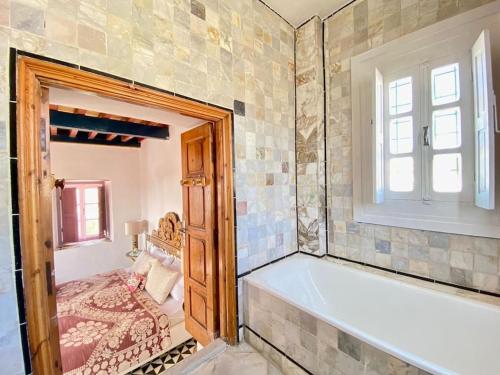 a bathroom with a bath tub and a window at Lella Khadija B&B Sidi bou said in Tunis