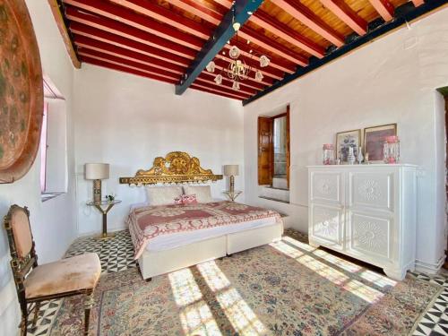 a bedroom with a king sized bed and a chair at Lella Khadija B&B Sidi bou said in Tunis