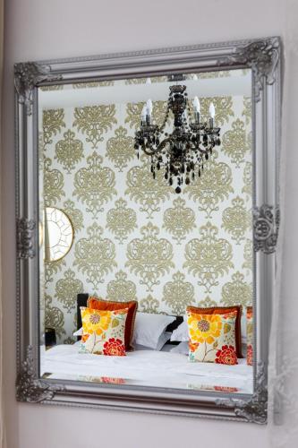 a mirror on a wall with a bed in a room at VILA LUCA-Hotel in Şirnea