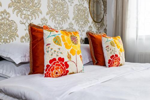 a bed with orange and white pillows on it at VILA LUCA-Hotel in Şirnea
