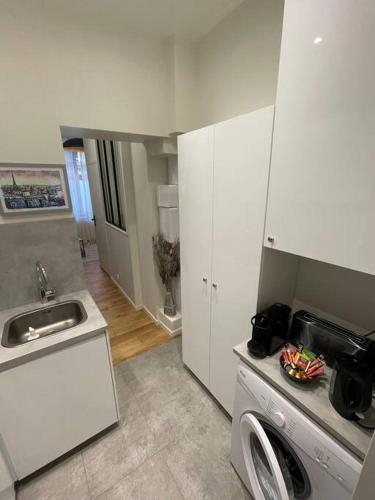 une cuisine avec un évier et une machine à laver dans l'établissement Brand new flat Eiffel Tower, à Paris