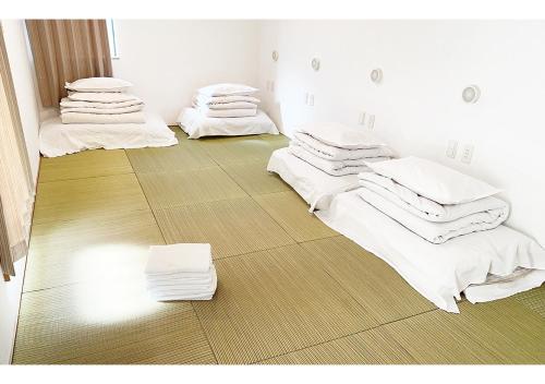 東京にあるHananogo Ikebukuro - Vacation STAY 16098vのベッド3台(白いシーツ、タオル付)が備わる客室です。
