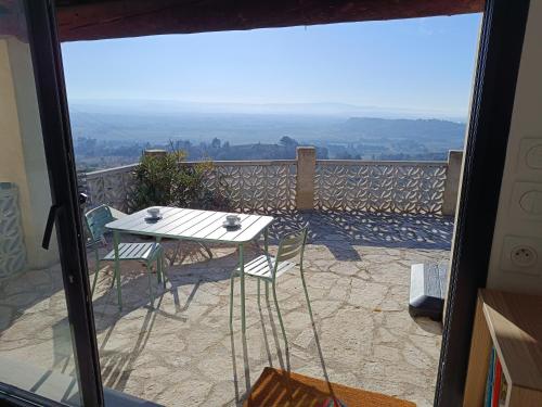 une table et des chaises sur un balcon avec vue dans l'établissement mas benette, à Saint-Hippolyte-le-Graveyron