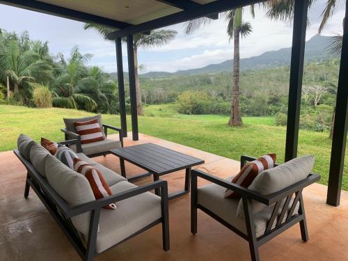 a porch with chairs and a table and a view at Villa Kamaya, Chamarel in Chamarel