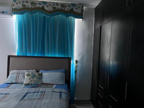 1 dormitorio con 1 cama con cortina azul en MM VILLAGE, en Río Hato