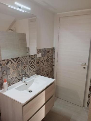 a bathroom with a sink and a mirror and a shower at L'alloggio delle vacanze estive in Corsano