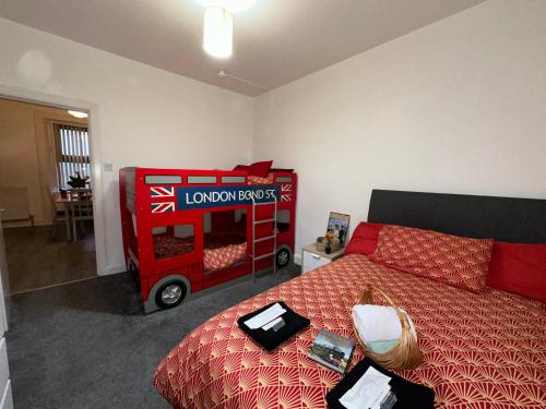 a room with a red bed and a red wagon at Station Signature Apartment near Lanark in Carstairs