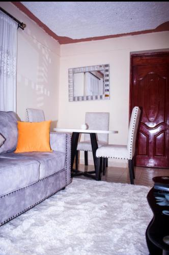 sala de estar con sofá, mesa y sillas en muindi homes en Kitui