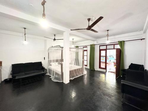 a room with a bed and a ceiling fan at Sana Studio in Weligama