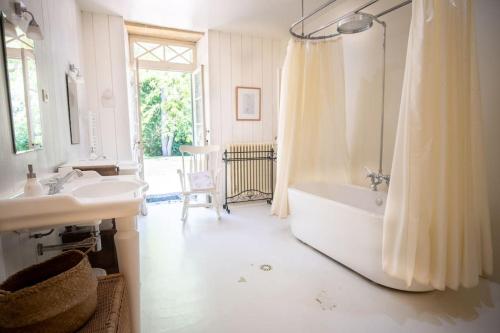 a bathroom with a tub and a sink and a shower at Belle maison de charme in Lussac